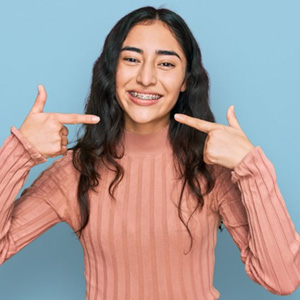 a girl pointing at her braces