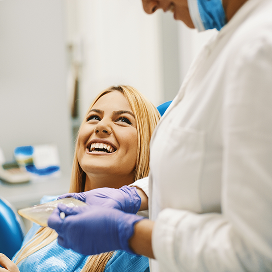 Blonde female patient smiling up at dentist in Los Gatos