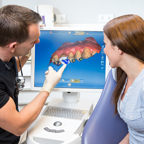 Dentist showing patient digital impression on monitor