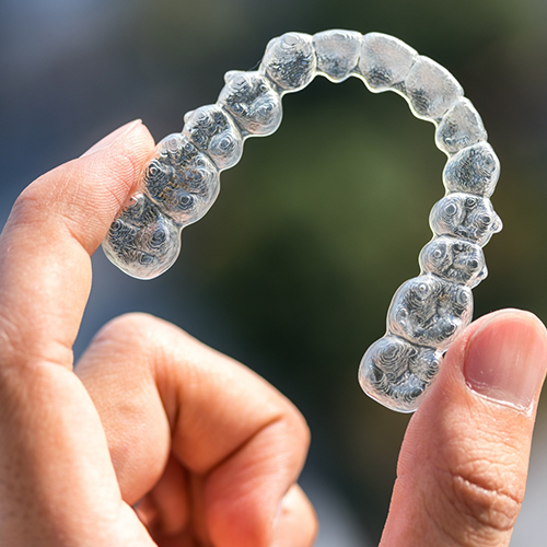 Close-up of hand holding clear aligner