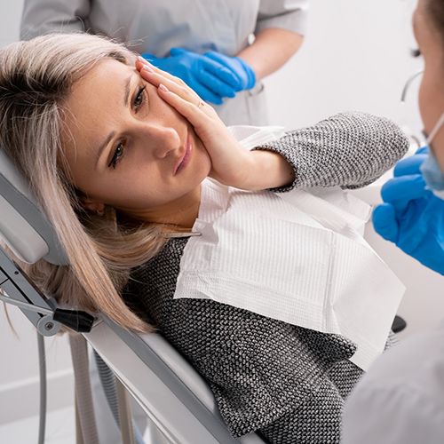 Woman with toothache visiting emergency dentist in Los Gatos