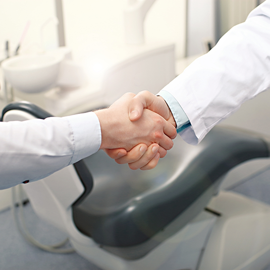 Dentist and patient shaking hands