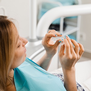 Patient holding clear aligner in treatment room