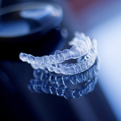 Two Invisalign aligners on a reflective table