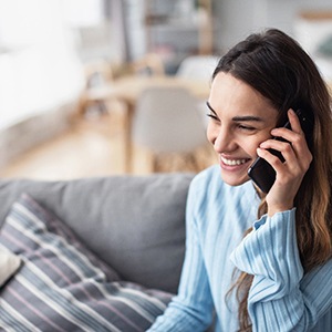 Woman smiling while talking on phone at home