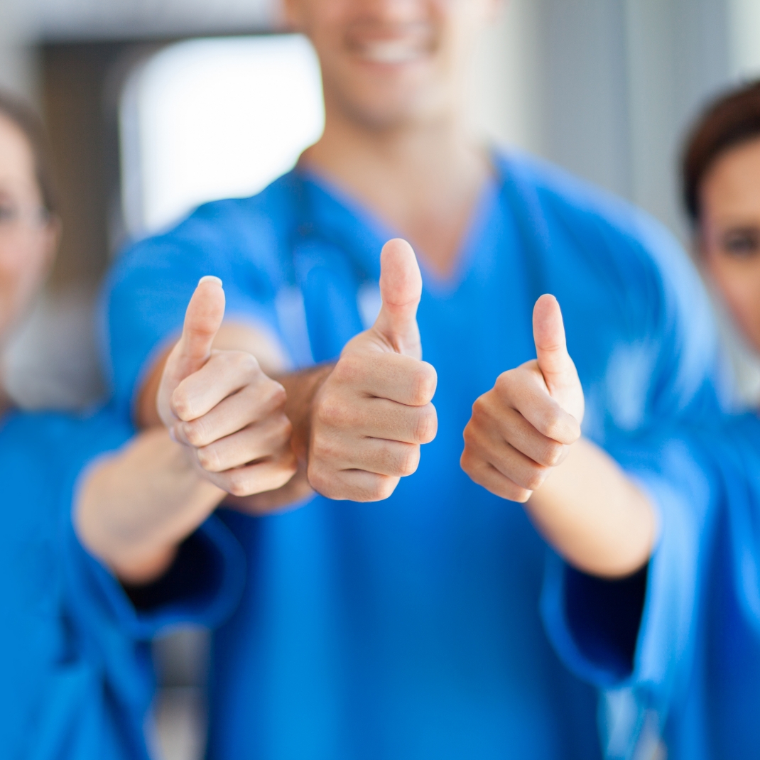 Dental team members all giving thumbs up