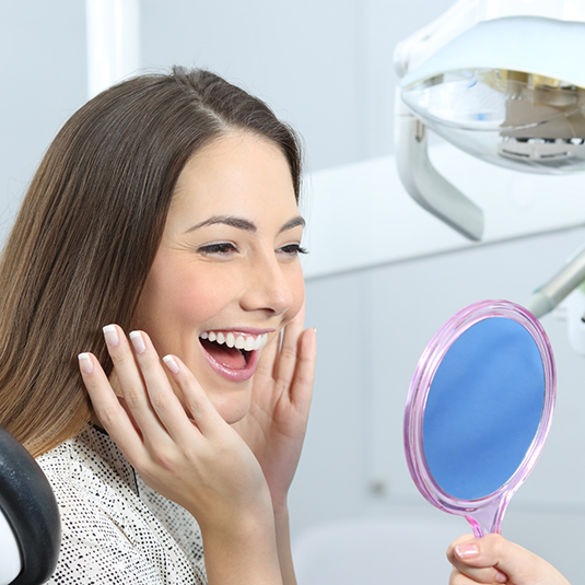 Woman looking in mirror and smiling